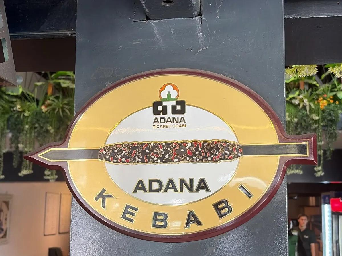 Salondaki kolona asılı Adana Kebabı tescil plaketi